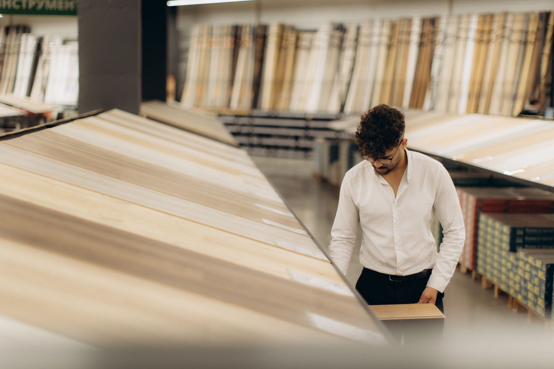 Man Selecting Wooden Flooring Inside a Hardware Store Display Layout Area